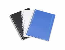 Caderno planner feito em capa cartonada com elástico para lacre. Com aproximadamente 62 folhas, o planner possui página para dados pessoais, calendários 2024 e 2025, planejamento anual, objetivos e metas, controle financeiro e resoluções do ano.