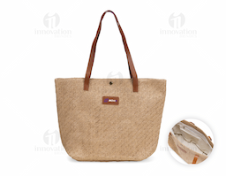 Bolsa confeccionada em palha trançada com fechamento em botão metálico de pressão. Possui revestimento interno em algodão e bolso com fechamento em zíper, além de alças e plaqueta frontal em couro sintético.