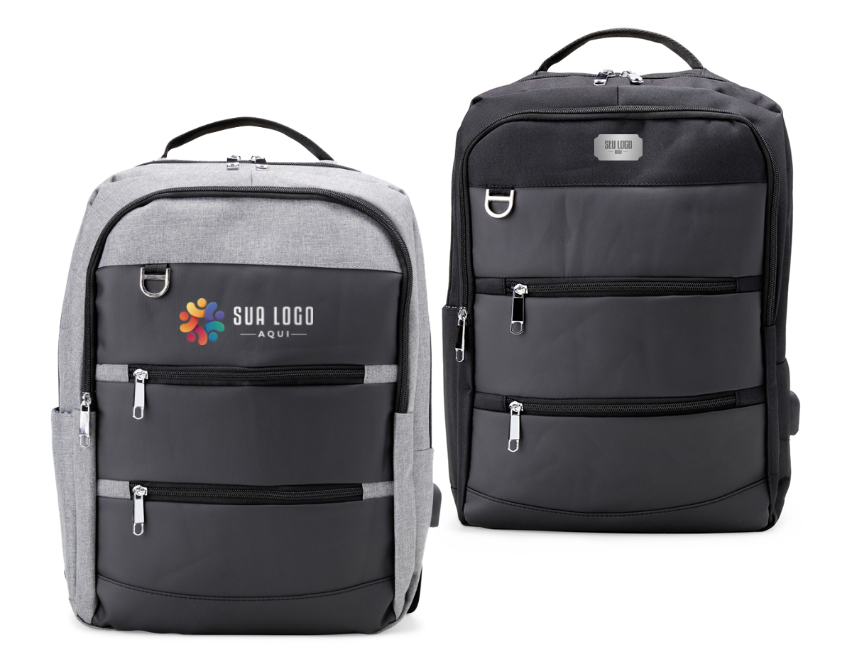 Mochila de nylon 26 Litros com detalhes em couro sintético e quatro compartimentos, sendo o principal com bolso para notebook 15,6. Com divisórias internas para acessórios, a mochila possui bolso lateral, suporte externo USB e alça para engate em malas de viagem.