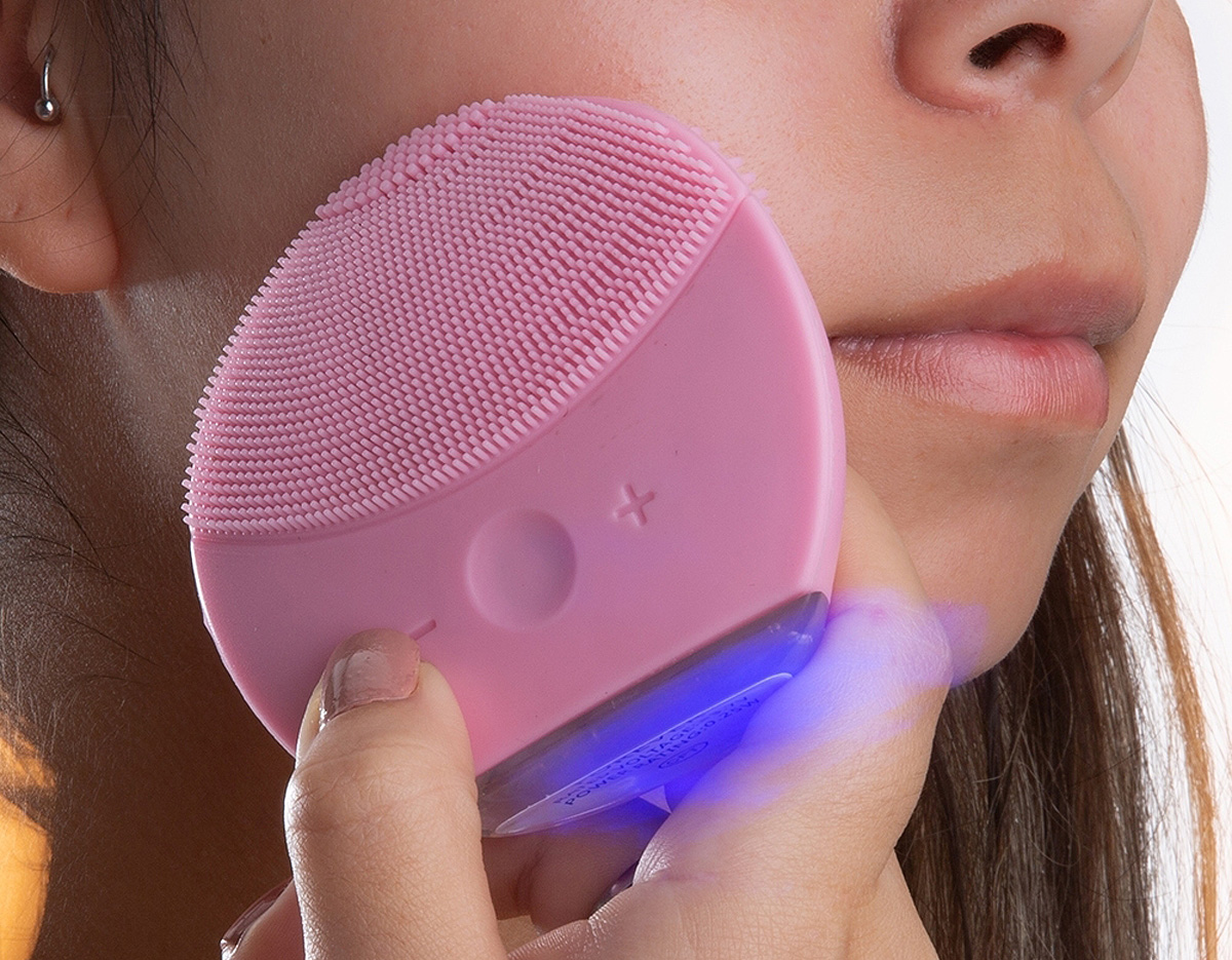 Massageador facial produzido em silicone resistente a água, a escova possui cerdas macias que limpam e massageiam a face. Sua parte frontal possui um botão de acionamento, além de dois botões para alteração entre os 6 modos de intensidade. A limpeza da face através do uso do produto, limpa profundamente os poros melhorando vários aspectos da pele, aumentando o fluxo sanguíneo, prevenindo contra rugas e outras impurezas na pele. O produto possui bateria recarregável com Voltagem de 3.7V e Potência de 0.25W. Acompanha cabo USB.